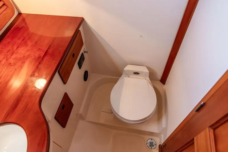 Drowsy Maggie Yacht Photos Pics 2001 Hinckley Ya Picn boat bathroom with wooden cabinetry and white toilet.