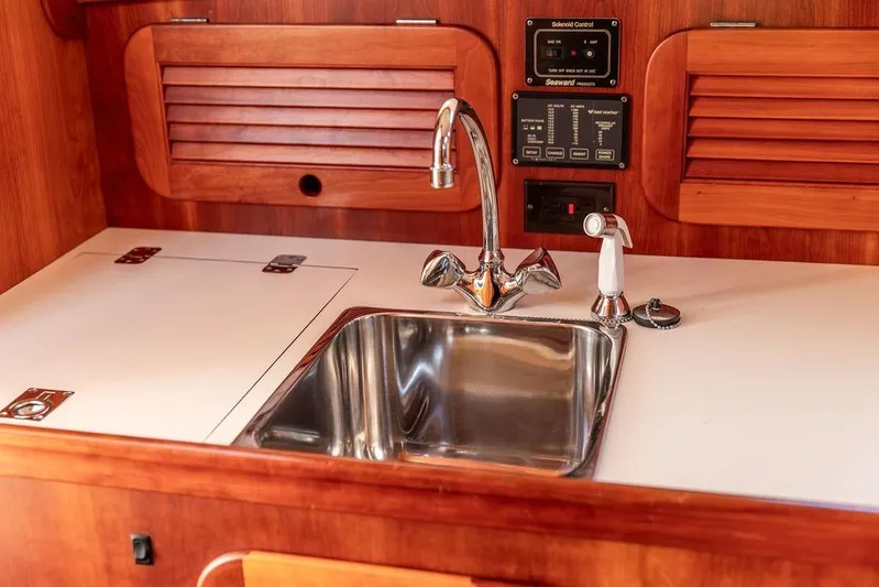 Drowsy Maggie Yacht Photos Pics Hinckley Ya Picn 2001 yacht kitchen with stainless steel sink and wooden cabinetry.