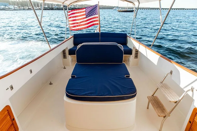 Drowsy Maggie Yacht Photos Pics 2001 Hinckley Ya Picn boat with blue seating and American flag on water.