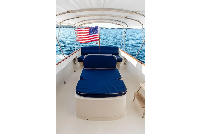 Drowsy Maggie Yacht Photos Pics 2001 Hinckley Ya Picn boat interior with blue seating and American flag on open water.