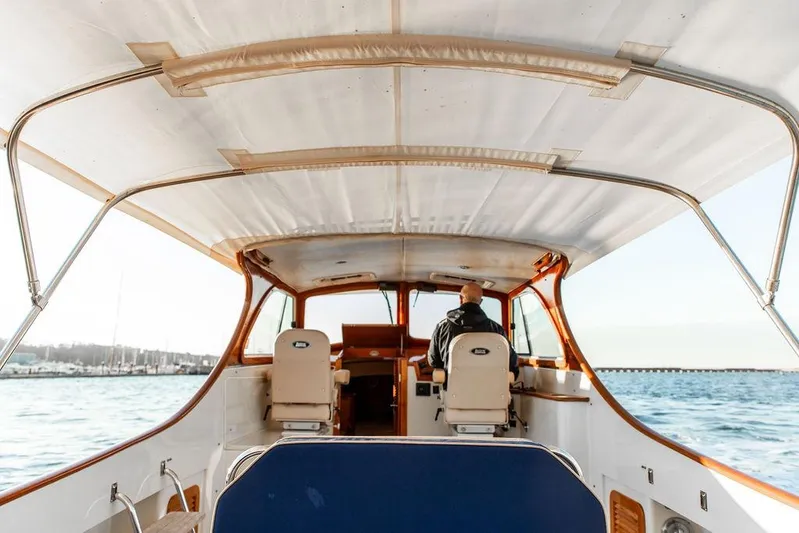 Drowsy Maggie Yacht Photos Pics 2001 Hinckley Ya Picn boat interior with person steering on open water.