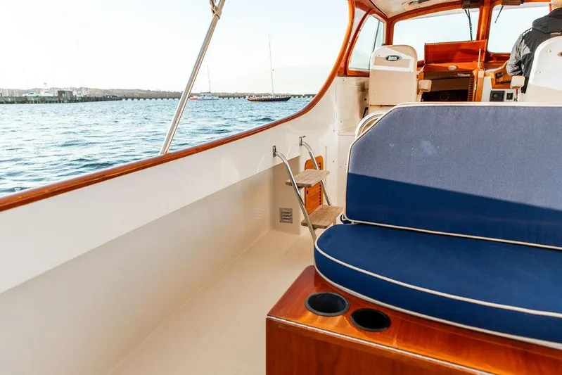 Drowsy Maggie Yacht Photos Pics 2001 Hinckley Ya Picn boat interior with blue seating, overlooking calm waters.
