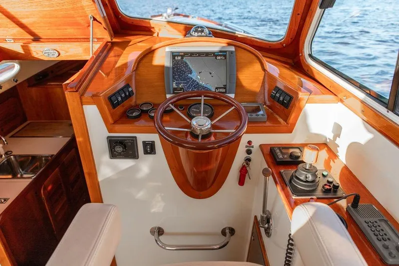 Drowsy Maggie Yacht Photos Pics Helm of 2001 Hinckley Ya Picn boat with wooden finish and navigation equipment.
