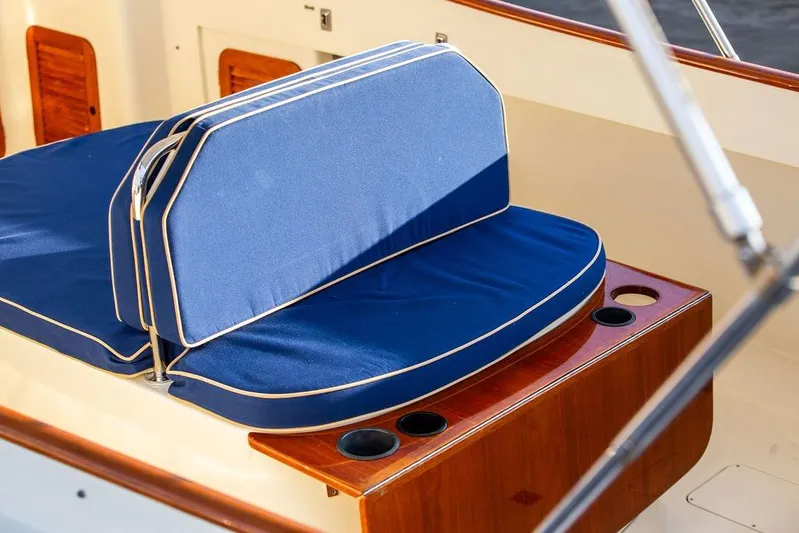 Drowsy Maggie Yacht Photos Pics Blue cushioned seating on 2001 Hinckley Ya Picn boat with wooden accents and cup holders.