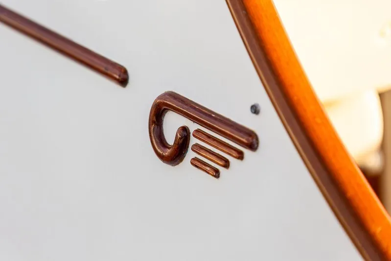 Drowsy Maggie Yacht Photos Pics Close-up of a 2001 Hinckley Ya Picn boat emblem on a wooden surface.