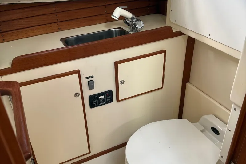 Dulce Yacht Photos Pics 2003 Dyer 29 Soft Top boat interior with sink and toilet, featuring wood accents.