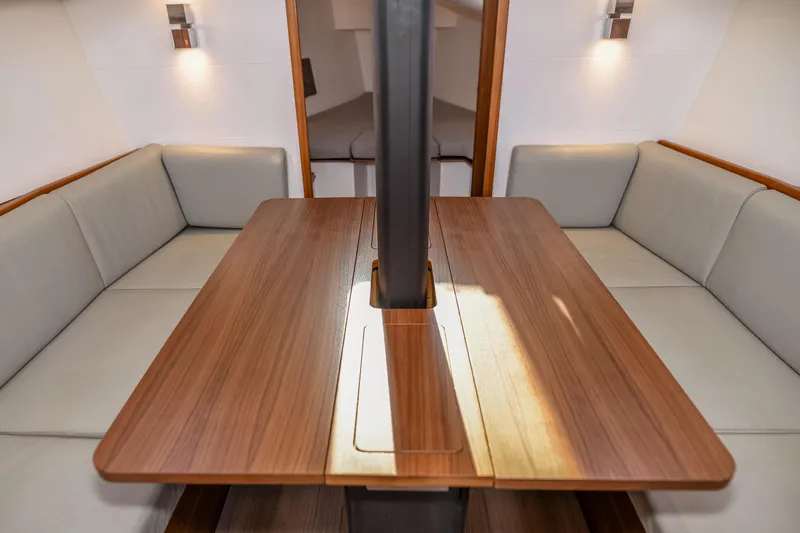 "mah Na Mah Na" Yacht Photos Pics Interior of 2020 J Boats J/112E sailboat with wooden table and cushioned seating.