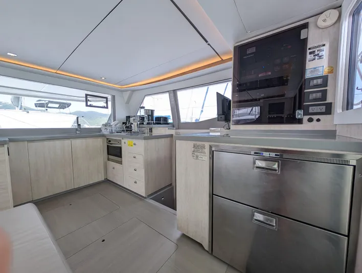 Salty Kiss Yacht Photos Pics Modern kitchen interior on a 2020 Leopard 45 yacht, featuring sleek cabinetry and appliances.