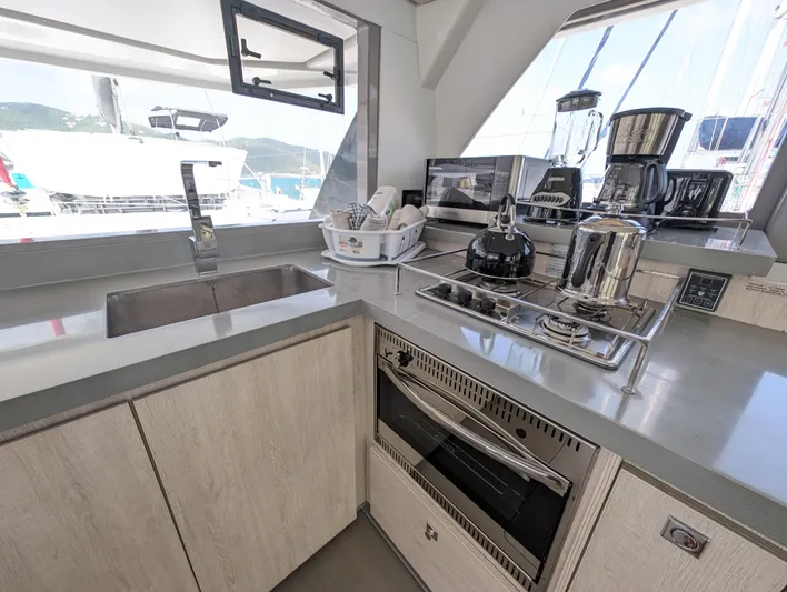 Salty Kiss Yacht Photos Pics Modern kitchen in a 2020 Leopard 45 yacht with appliances and sleek countertops.
