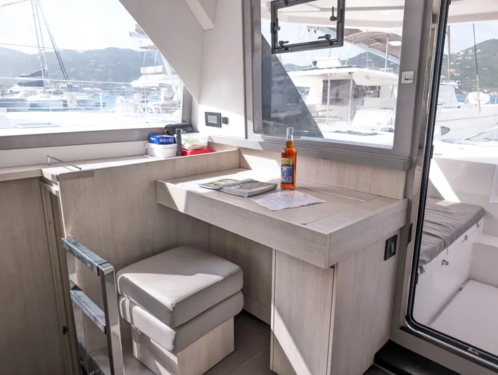 Salty Kiss Yacht Photos Pics Modern interior of 2020 Leopard 45 yacht with desk, window, and seating.