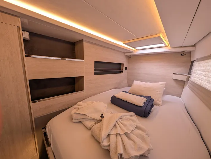 Salty Kiss Yacht Photos Pics Luxurious cabin interior of 2020 Leopard 45 yacht with cozy bedding and ambient lighting.