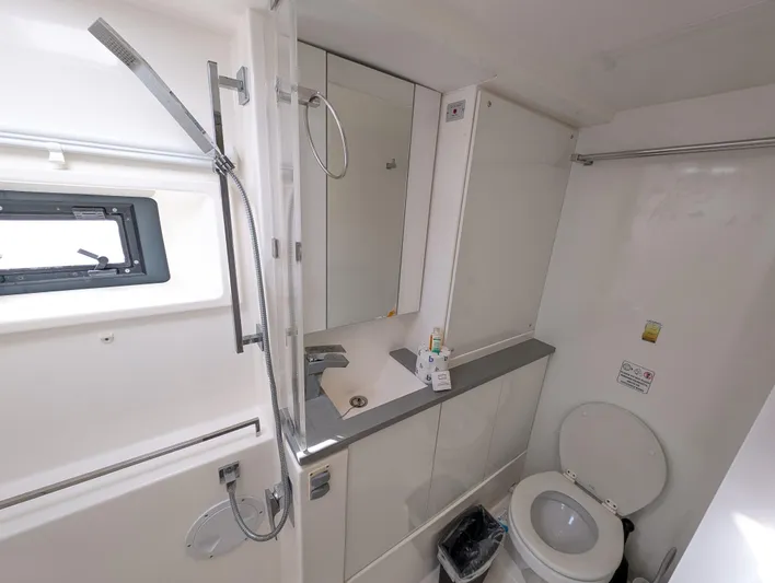 Salty Kiss Yacht Photos Pics Modern bathroom in a 2020 Leopard 45 yacht, featuring a shower, sink, and toilet.