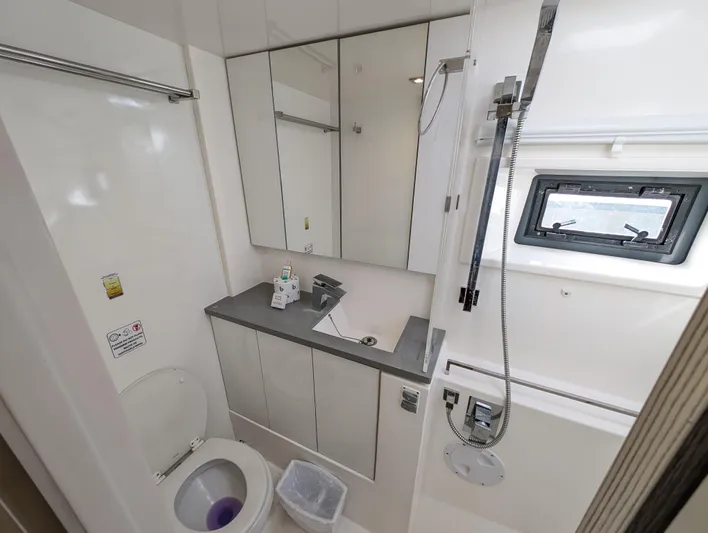 Salty Kiss Yacht Photos Pics Modern bathroom in a 2020 Leopard 45 yacht with shower, sink, and toilet.