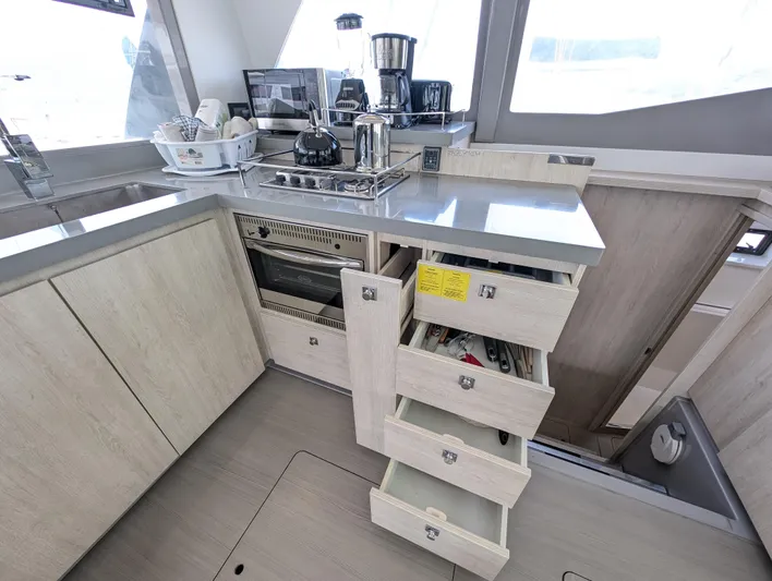 Salty Kiss Yacht Photos Pics Modern kitchen in a 2020 Leopard 45 yacht with open drawers and appliances.