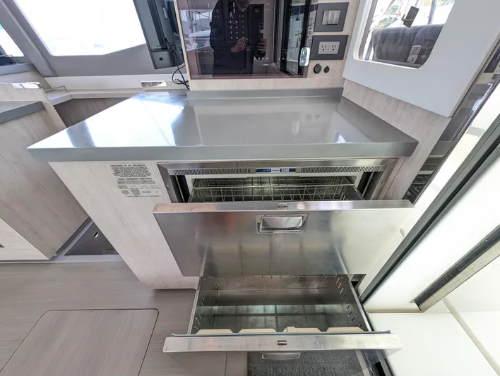 Salty Kiss Yacht Photos Pics Modern kitchen area in a 2020 Leopard 45 yacht with open stainless steel drawers.