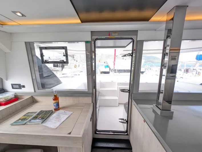 Salty Kiss Yacht Photos Pics Interior of 2020 Leopard 45 yacht with table, documents, and outdoor view.