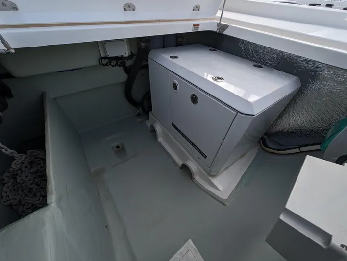 Salty Kiss Yacht Photos Pics Storage compartment in a 2020 Leopard 45 catamaran, featuring a secured metal box and coiled rope.