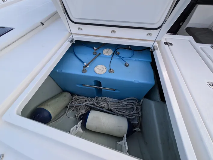 Salty Kiss Yacht Photos Pics Open storage compartment on Leopard 45 yacht with blue tank and ropes.