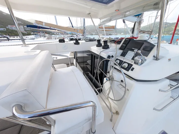 Salty Kiss Yacht Photos Pics Helm of 2020 Leopard 45 catamaran with modern navigation equipment and white seating.