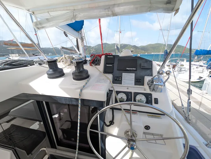 Salty Kiss Yacht Photos Pics Helm of 2020 Leopard 45 catamaran with navigation equipment and scenic marina view.