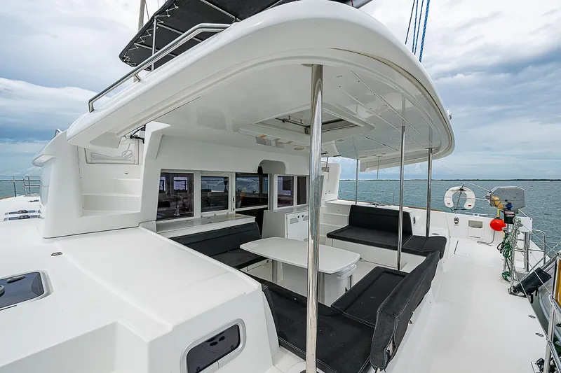 Somewhere Yacht Photos Pics 2018 Lagoon 450 catamaran with spacious outdoor seating and ocean view.