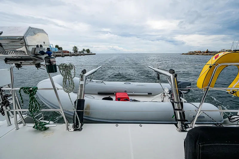 Somewhere Yacht Photos Pics Lagoon 450 catamaran deck with dinghy, ocean view, and overcast sky, 2018 model.