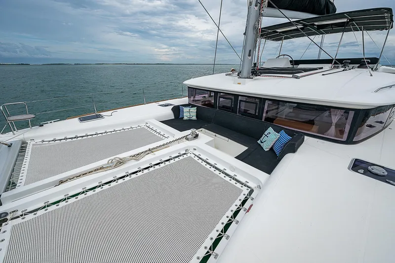 Somewhere Yacht Photos Pics Lagoon 450 catamaran, 2018 model, with spacious deck and netting, sailing on calm waters.
