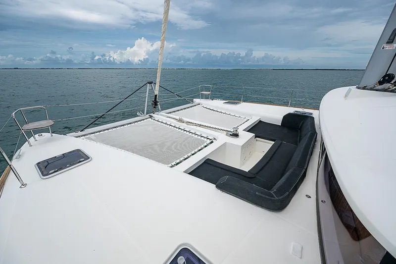 Somewhere Yacht Photos Pics Lagoon 450 catamaran 2018, spacious deck with seating, sailing on calm ocean waters.