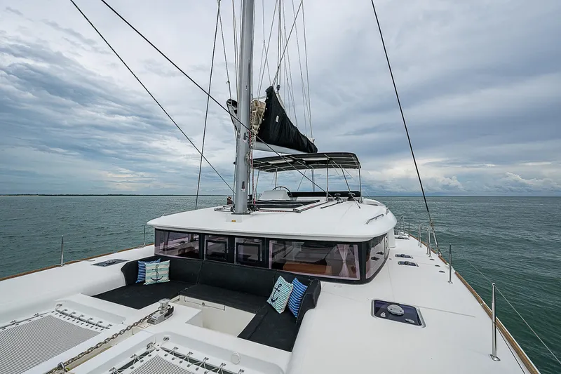Somewhere Yacht Photos Pics 2018 Lagoon 450 catamaran sailing on open sea under cloudy skies.