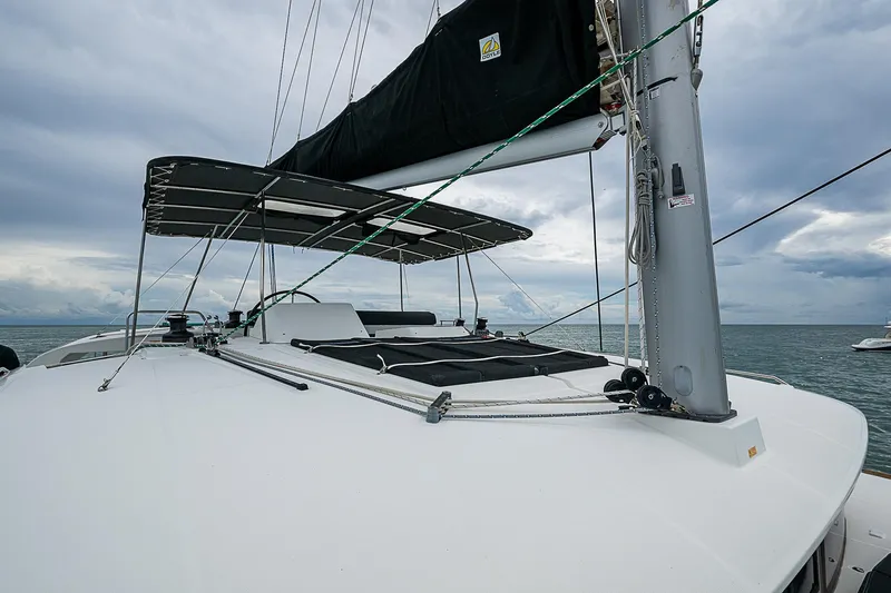 Somewhere Yacht Photos Pics 2018 Lagoon 450 catamaran deck with sails, under cloudy sky.