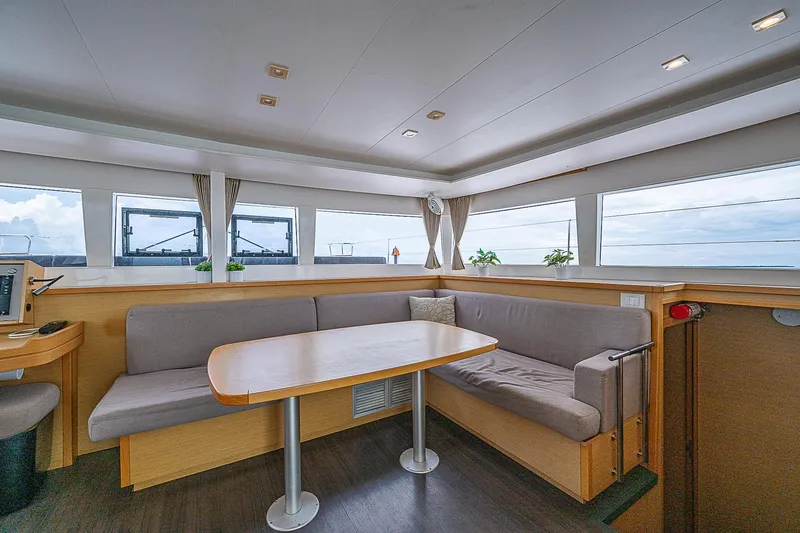 Somewhere Yacht Photos Pics Spacious interior of 2018 Lagoon 450 catamaran with panoramic windows and cozy seating area.