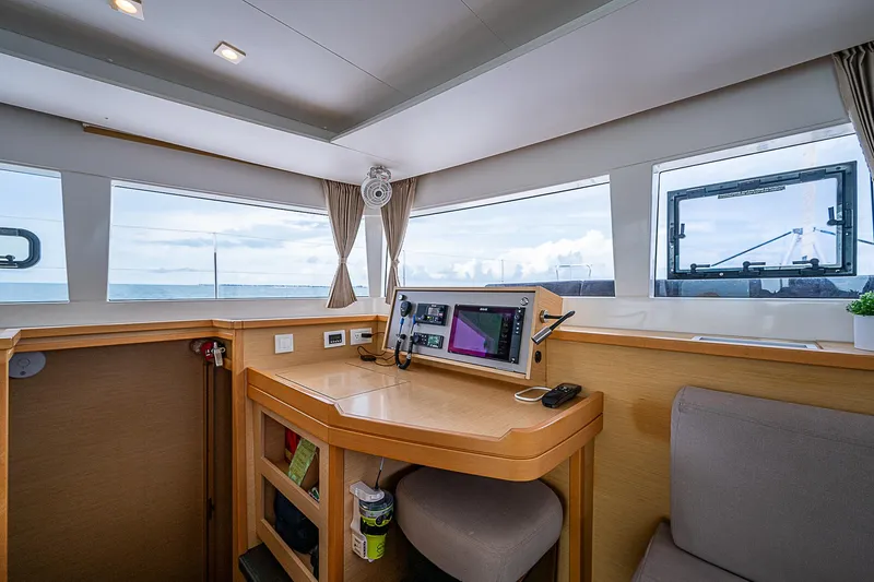 Somewhere Yacht Photos Pics Interior of 2018 Lagoon 450 catamaran with navigation station and panoramic windows.