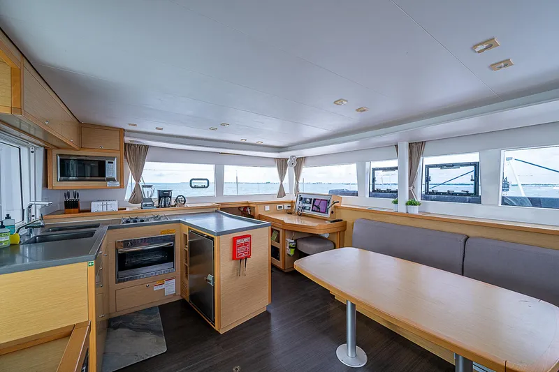 Somewhere Yacht Photos Pics Spacious interior of 2018 Lagoon 450 catamaran with modern kitchen and dining area.