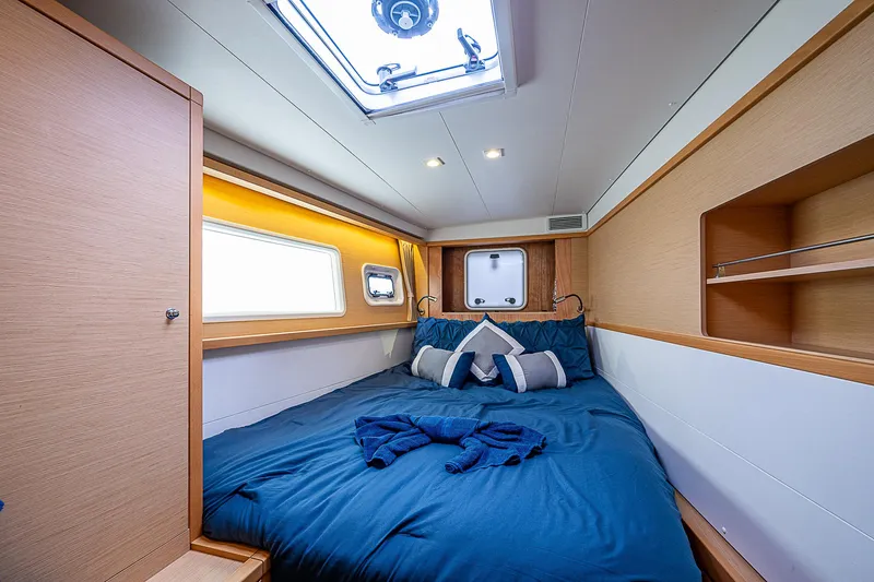 Somewhere Yacht Photos Pics Luxurious cabin interior of 2018 Lagoon 450 catamaran with cozy bed and modern design.