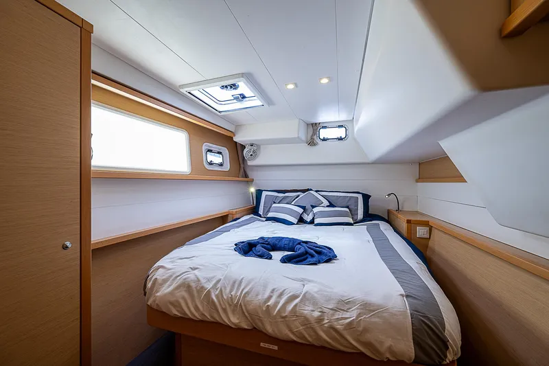 Somewhere Yacht Photos Pics Luxurious cabin interior of 2018 Lagoon 450 catamaran with cozy bed and modern design.