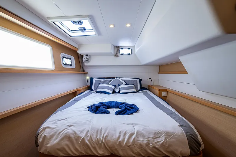 Somewhere Yacht Photos Pics Luxurious cabin interior of 2018 Lagoon 450 catamaran with cozy bed and modern design.