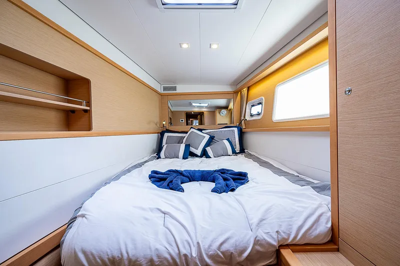 Somewhere Yacht Photos Pics Luxurious cabin interior of 2018 Lagoon 450 catamaran with cozy bedding and modern design.