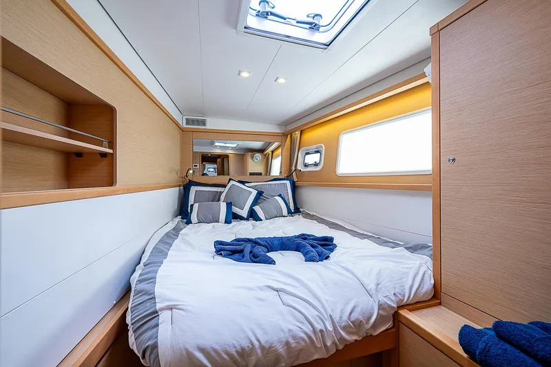 Somewhere Yacht Photos Pics Luxurious cabin interior of 2018 Lagoon 450 catamaran with cozy bedding and modern design.