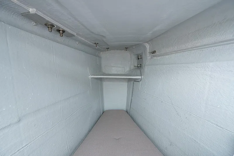 Somewhere Yacht Photos Pics Interior storage compartment of 2018 Lagoon 450 catamaran, featuring white walls and shelving.