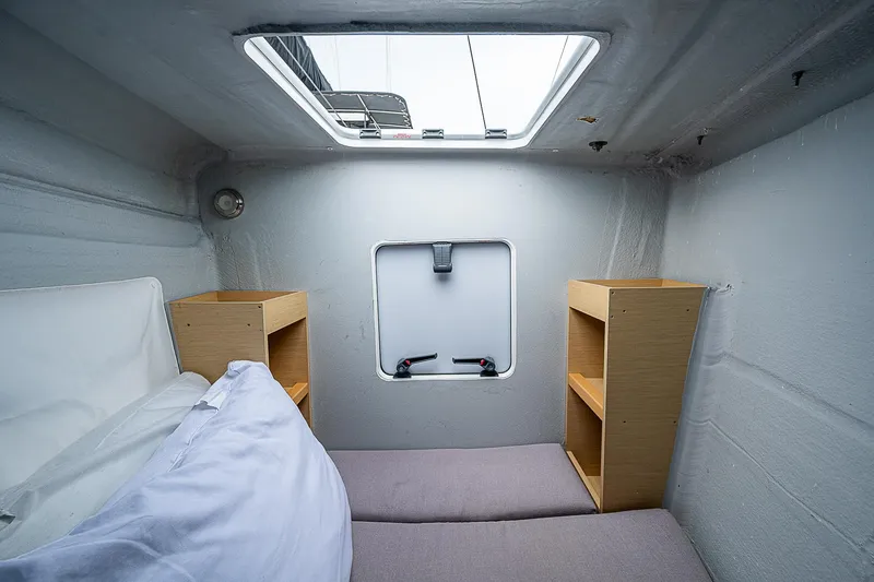 Somewhere Yacht Photos Pics Interior cabin of 2018 Lagoon 450 catamaran with bed and storage shelves.