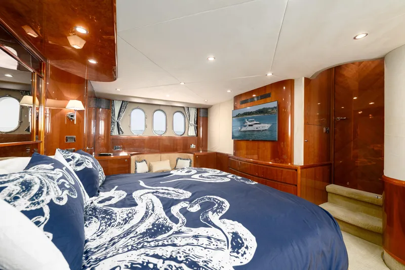 Ocaralia Yacht Photos Pics Luxurious 2008 Viking Princess 75 yacht bedroom with elegant wood paneling and nautical-themed bedding.