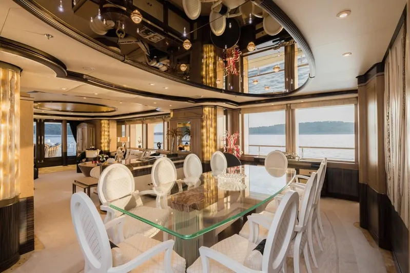 Belle Anna Yacht Photos Pics Luxurious yacht interior with elegant dining area, glass table, and scenic ocean view. ISA 500, 2012.