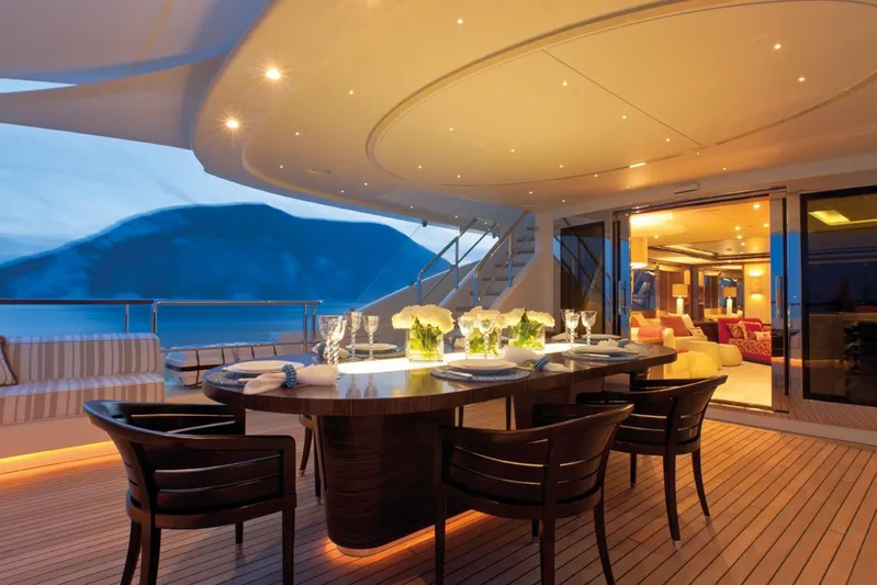 Belle Anna Yacht Photos Pics Luxurious yacht deck with dining area, elegant lighting, and scenic ocean view, ISA 500, 2012 model.
