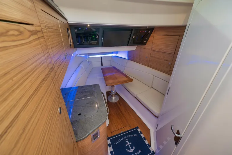  Yacht Photos Pics 2020 Boston Whaler 380 Realm cabin interior with wood accents and cozy seating area.