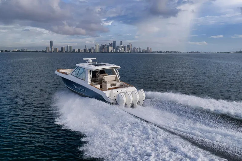  Yacht Photos Pics 2020 Boston Whaler 380 Realm cruising on open water with city skyline backdrop.