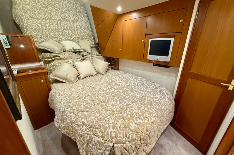  Yacht Photos Pics Luxurious bedroom in 2000 Ocean Yachts 48, featuring elegant bedding and wood cabinetry.