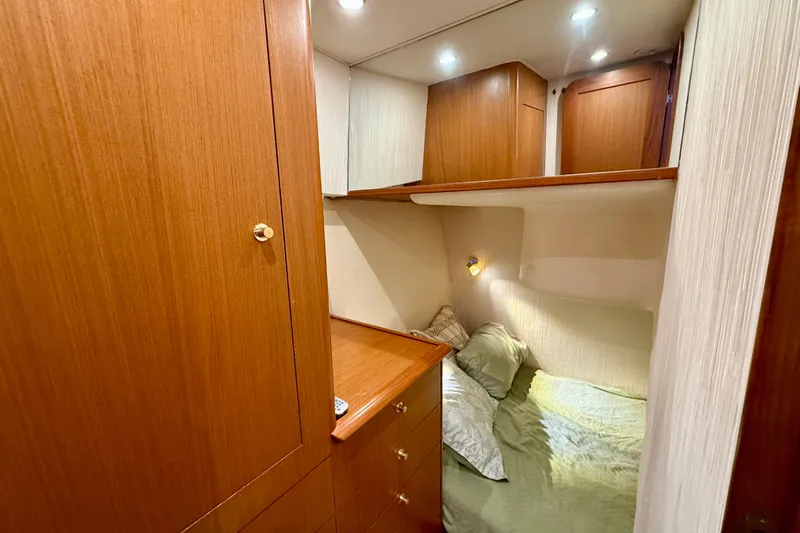  Yacht Photos Pics Cozy cabin interior of 2000 Ocean Yachts 48 with wooden cabinetry and soft lighting.