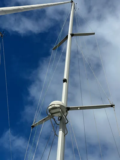 Knot Inspired Yacht Photos Pics Mast of 2002 Beneteau 411 sailboat against a blue sky with clouds.