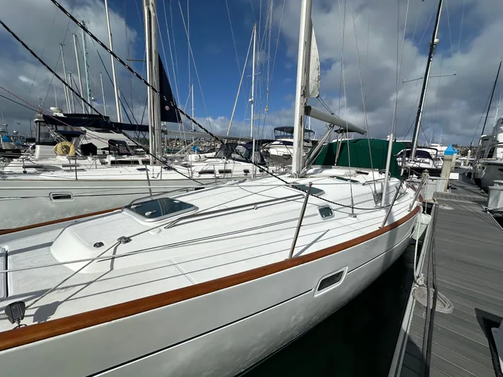 Knot Inspired Yacht Photos Pics 2002 Beneteau 411 sailboat docked at marina under cloudy sky.