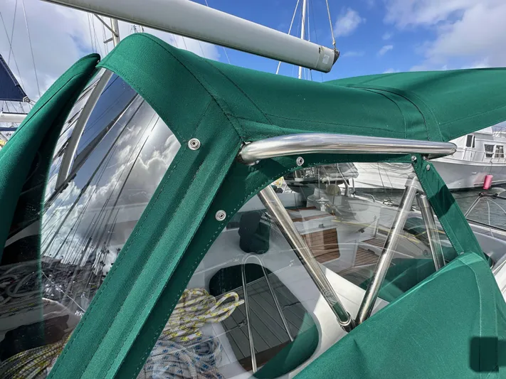 Knot Inspired Yacht Photos Pics Green canopy on a 2002 Beneteau 411 sailboat, showcasing cockpit details and clear windows.